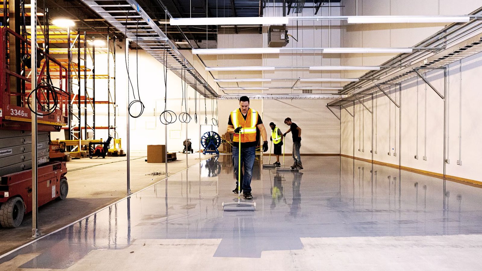 Cleaning a polished concrete garage floor with a microfiber mop.