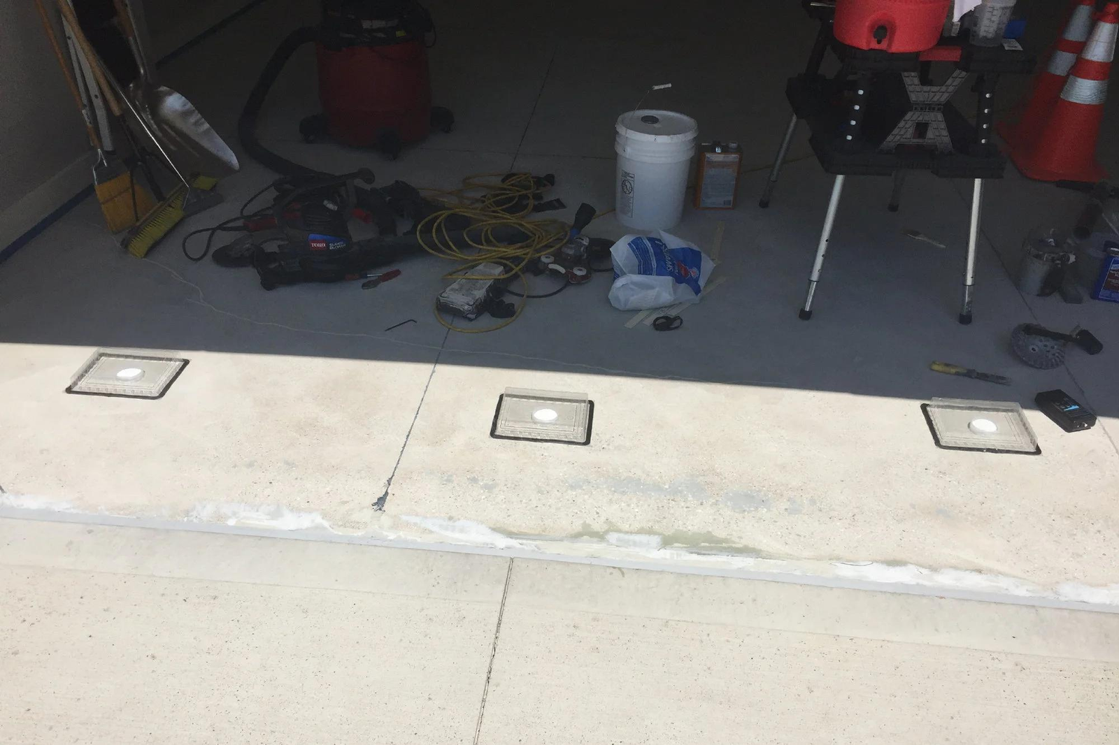 Homeowner speaking with a professional contractor about polyurea garage floor coating, surface preparation, moisture testing, and installation details inside a residential garage.