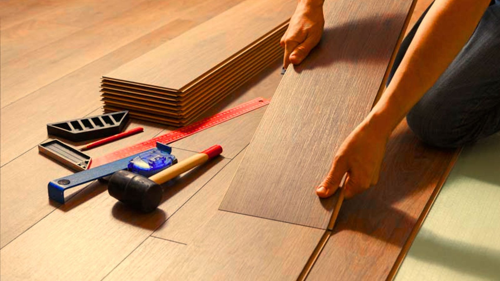 Professional installing luxury vinyl plank flooring in a residential interior.