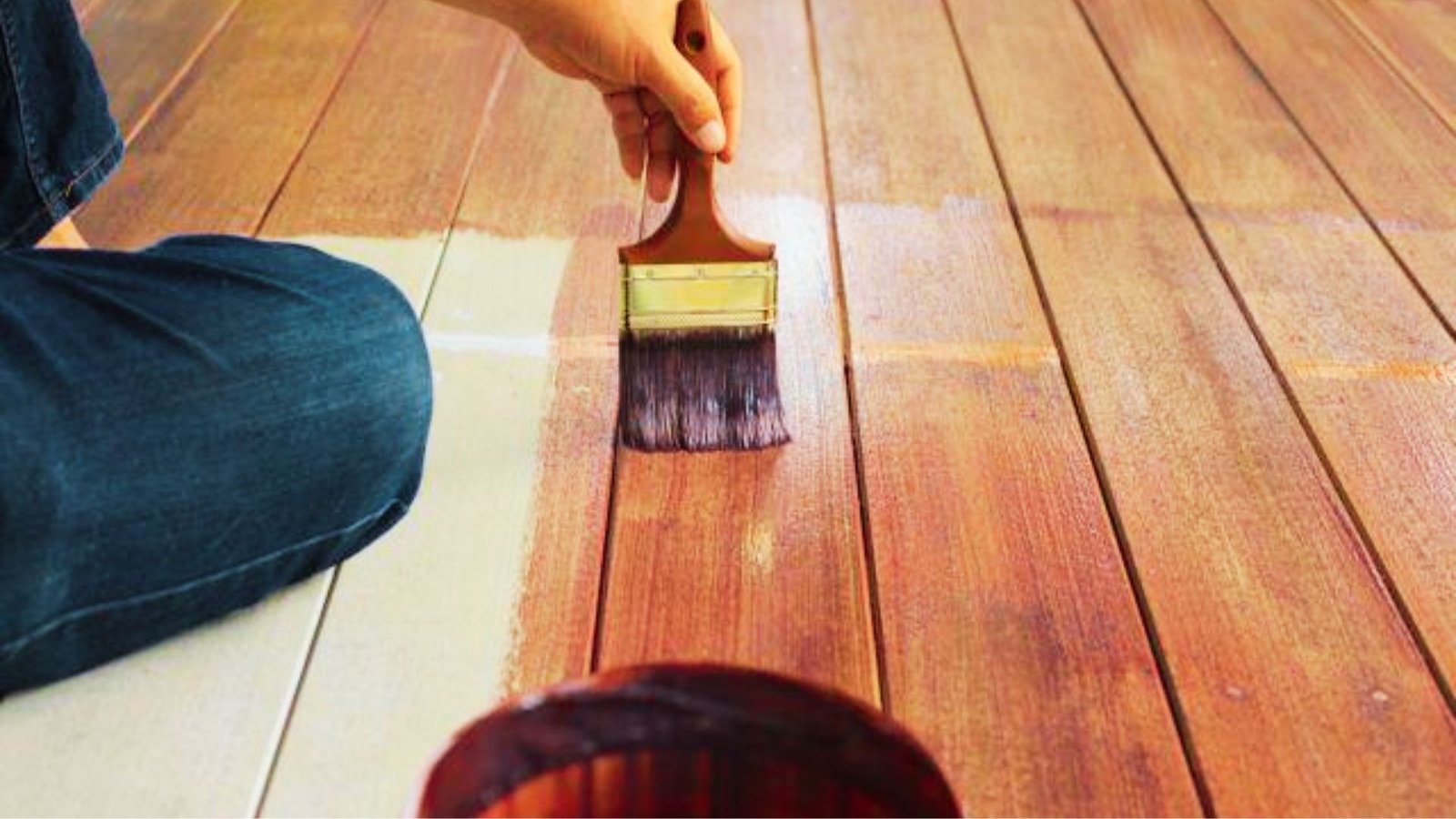Person painting the hardwood floor.